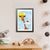 A young white boy with blonde hair sits on a cloud that brings him up to a giraffe's face (A4 framed)