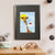 A young white boy with blonde hair sits on a cloud that brings him up to a giraffe's face (A3 framed with black mount)