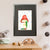A green caterpillar shelters from the rain under a vibrant red mushroom (A3 framed with black mount)