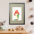 A green caterpillar shelters from the rain under a vibrant red mushroom (A3 framed with grey mount)