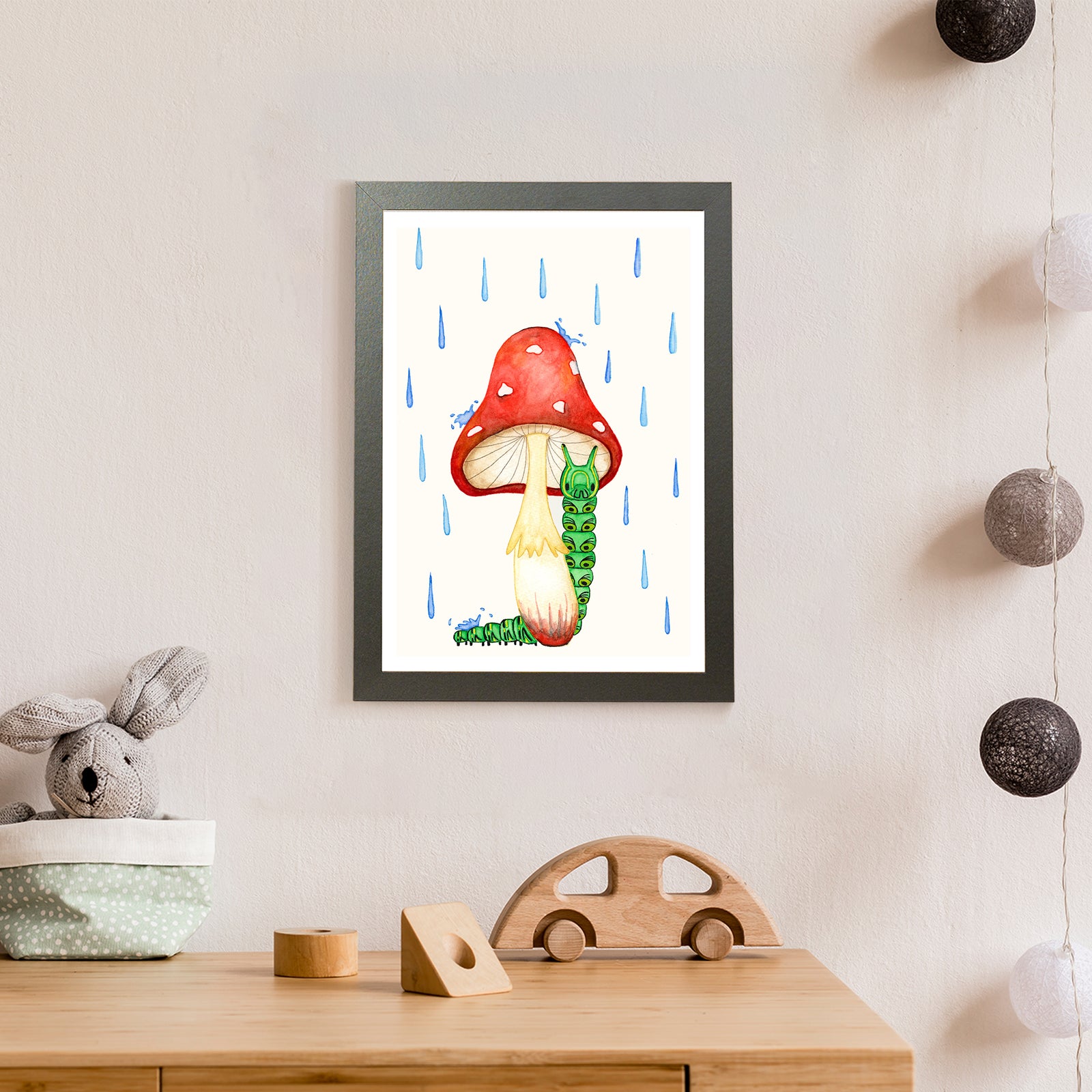 A green caterpillar shelters from the rain under a vibrant red mushroom (print only)